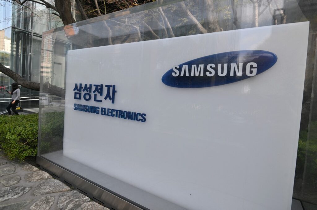 A woman walks past a signboard of Samsung Electronics displayed outside the company's Seocho building in Seoul on April 5, 2024. - Samsung Electronics said on April 5, it expects first-quarter operating profits to rise more than 10-fold year on year as chip prices recover. (Photo by Jung Yeon-je / AFP)