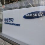 A woman walks past a signboard of Samsung Electronics displayed outside the company's Seocho building in Seoul on April 5, 2024. - Samsung Electronics said on April 5, it expects first-quarter operating profits to rise more than 10-fold year on year as chip prices recover. (Photo by Jung Yeon-je / AFP)